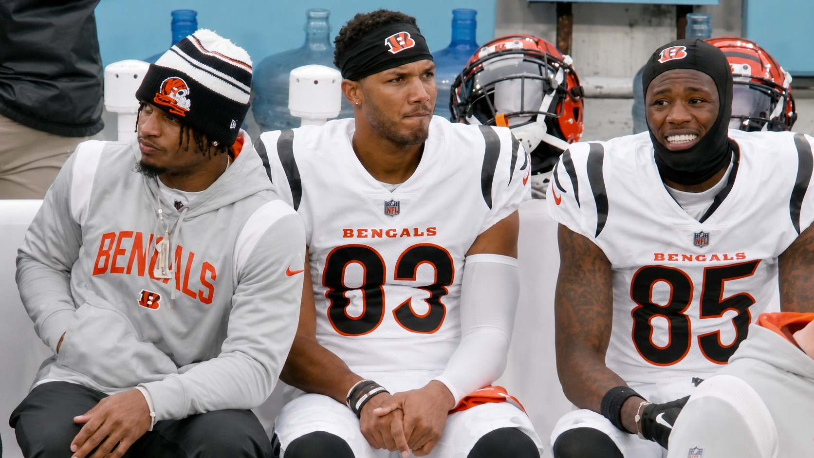 Cincinnati Bengals players relax on a white bench outdoors in white jerseys and hoodies during a casual July 4th team moment, with one player highlighted by on-screen text as “HE’S A GLIZZY GOBBLER!” in a viral video shared by the NFL.