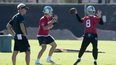 Las Vegas Raiders quarterbacks Fernando Mendoza (15) and Kirk Cousins (8) throw the ball as assistant head coach Mike McCoy (left) watches during minicamp at In…