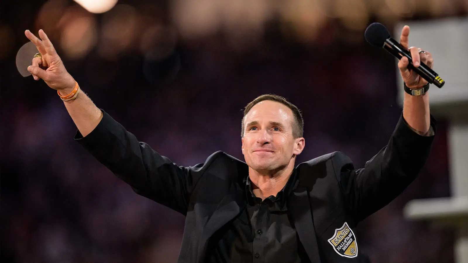 Oct 17, 2024; New Orleans, Louisiana, USA; New Orleans Saints retired quarterback Drew Brees (9) reacts during his hall of fame ceremony at halftime against the…