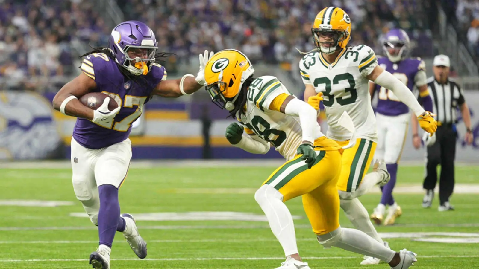 Jan 4, 2026; Minneapolis, Minnesota, USA; Minnesota Vikings running back Jordan Mason (27) runs the ball against Green Bay Packers cornerback Trevon Diggs (28)…