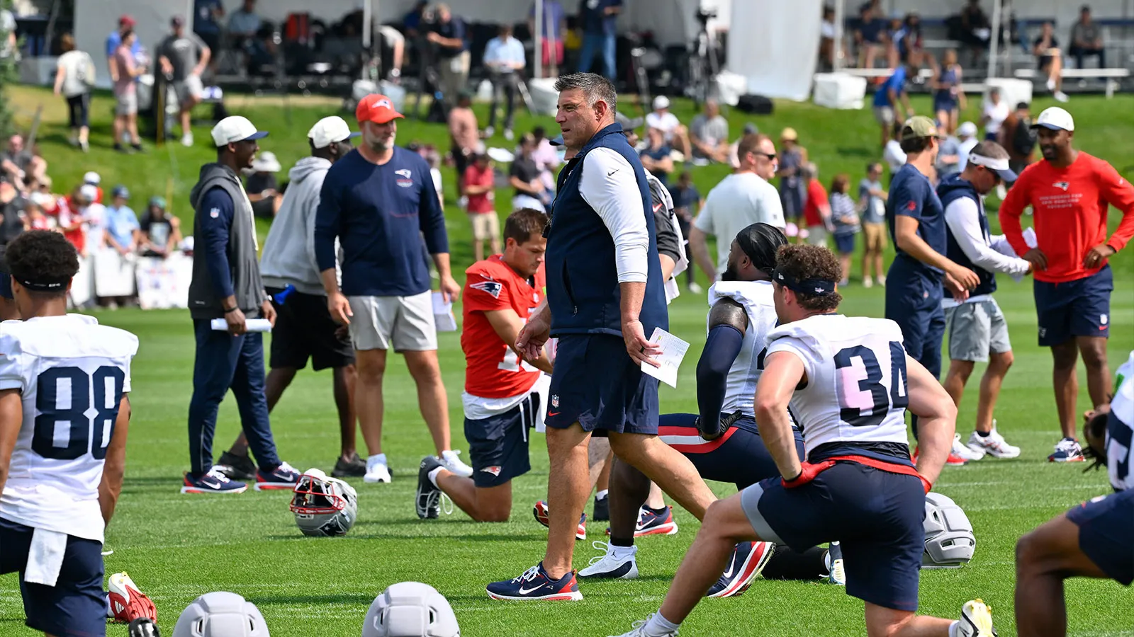 Jul 28, 2026; Foxborough, MA, USA; New England Patriots head coach Mike Vrabel watches players warm up for training camp at Gillette Stadium. Mandatory Credit:…