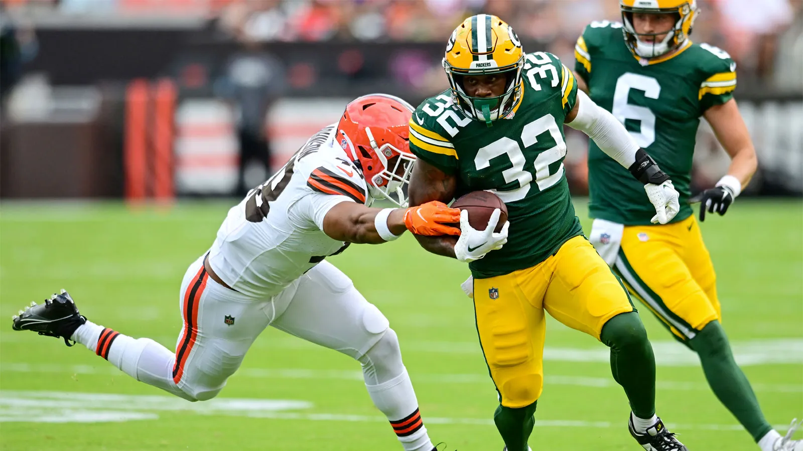 Aug 10, 2024; Cleveland, Ohio, USA; Green Bay Packers running back MarShawn Lloyd (32) runs with the ball as Cleveland Browns linebacker Caleb Johnson (48) defe…