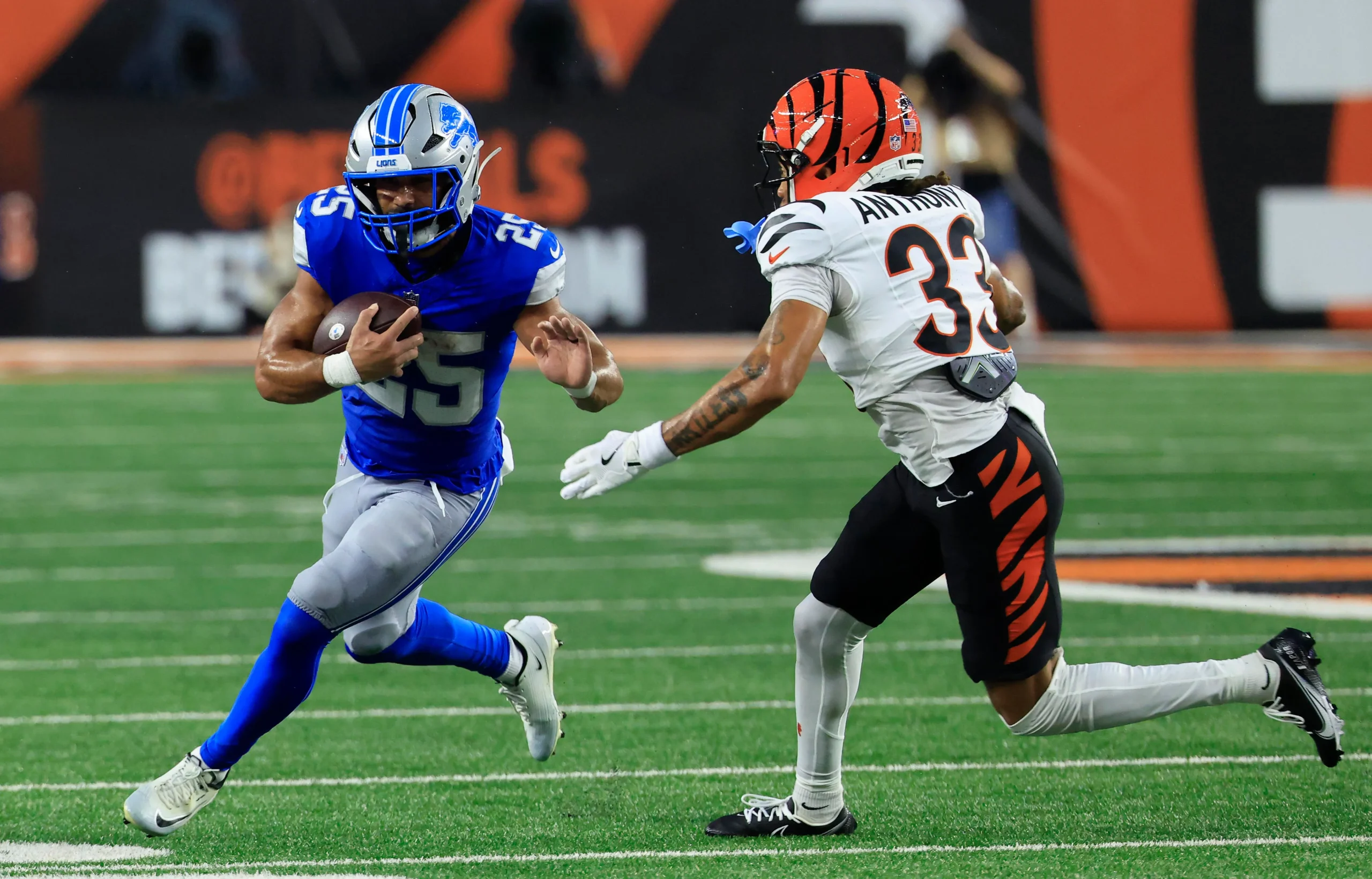 CINCINNATI, OHIO - AUGUST 13: Jacob Saylors #25 of the Detroit Lions is chased by Daijahn Anthony #33 of the Cincinnati Bengals during the second quarter of a p…